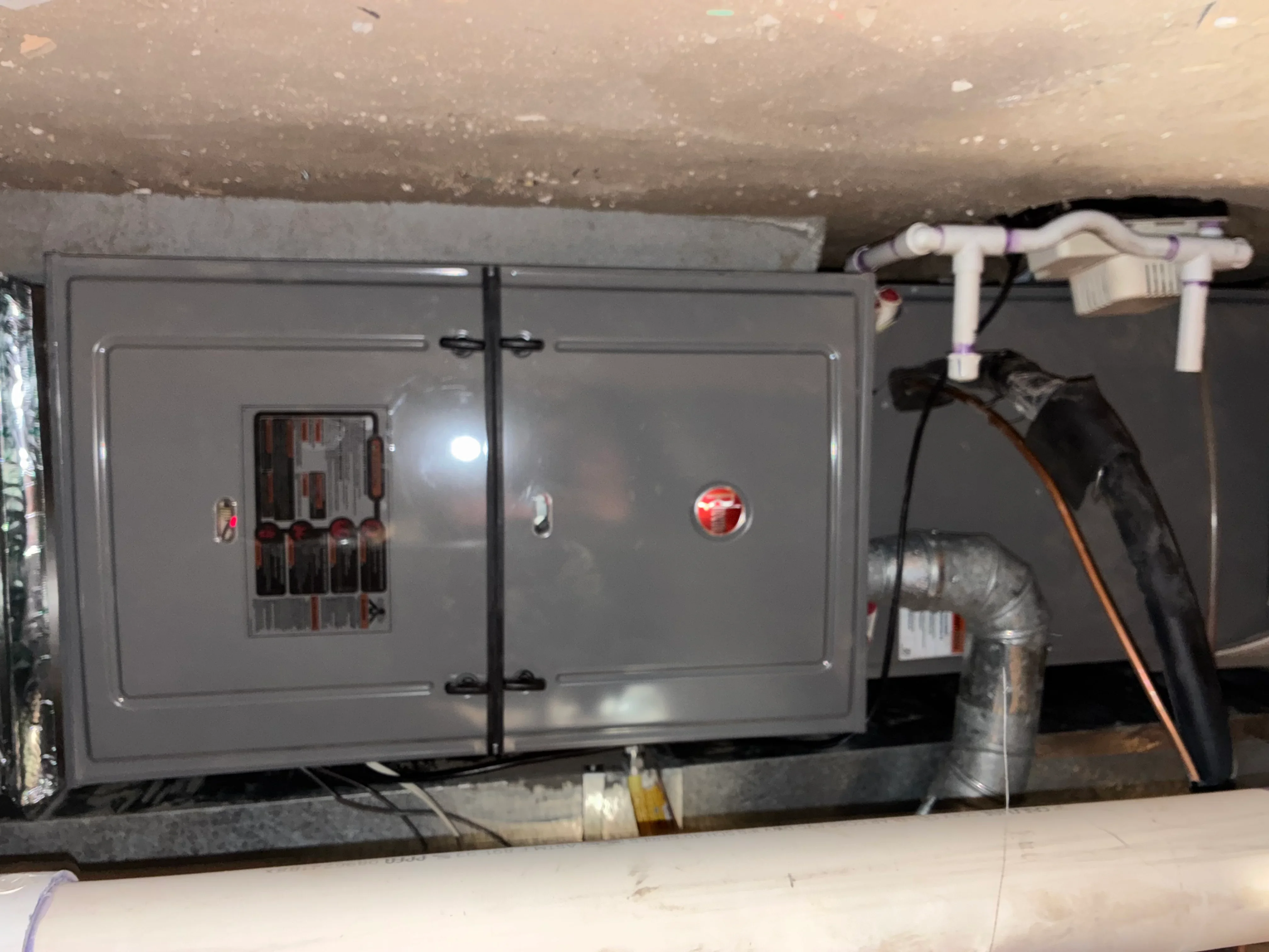 Dual-door electrical panel with HVAC controls and insulated ductwork in basement mechanical room